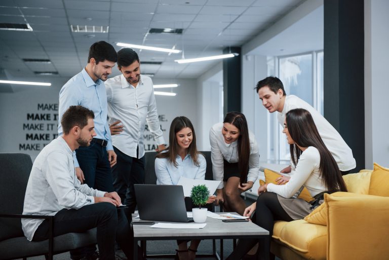 IT support professionals in a modern office analyzing cloud services Owosso architecture across multiple monitors.